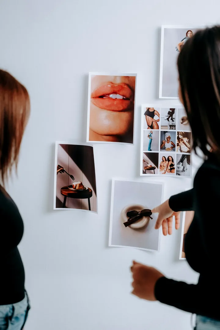 A woman pointing at pictures pinned to a wall