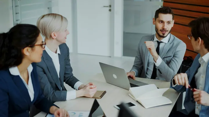 Four colleagues in a business meeting around a table